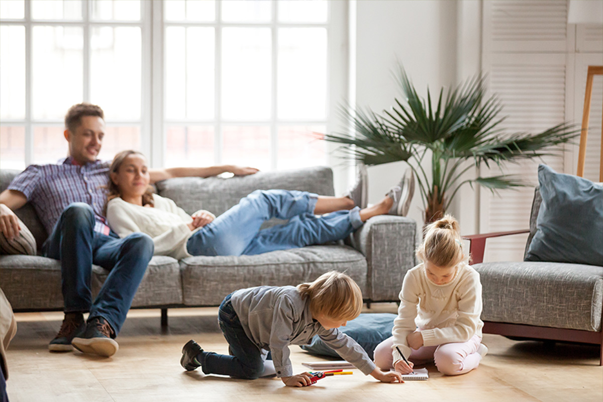 Image of a family sitting in the living room of their newly built, energy-efficient home, appearing relaxed and comfortable.