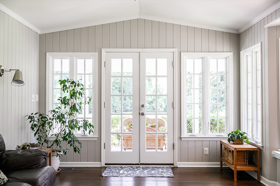 Image of a home's interior, showcasing elegant white French doors. The doors stand out with their classic design, glass panels, and the way they enhance the room's ambiance, possibly leading to another room or outdoor area.