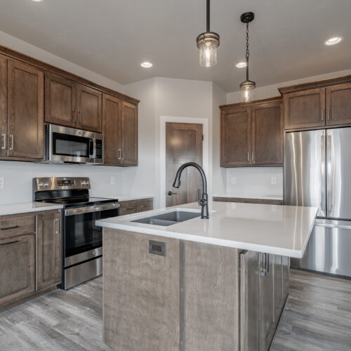 Image of the kitchen in a newly built home, highlighting its modern appliances, sleek design, and spacious layout.