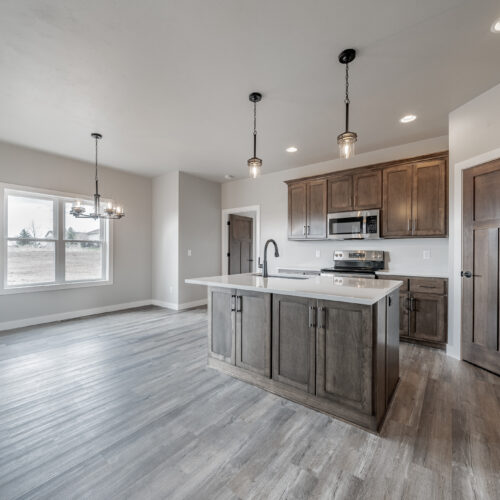 Wide-angle image of a newly built home's kitchen, showcasing its modern appliances, spacious layout, and stylish design.