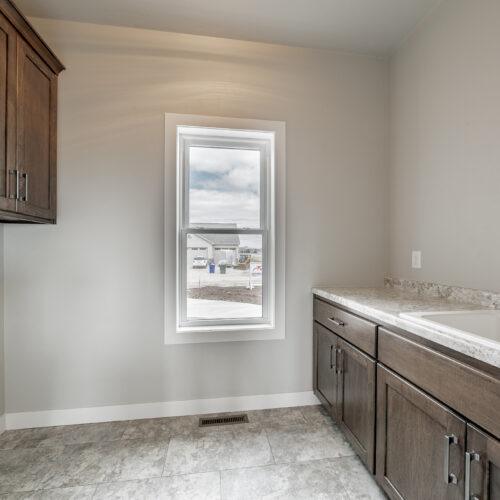 Image of the laundry room in a newly built home, showcasing ample storage space and a clean, organized layout.